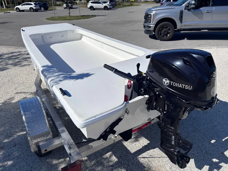 Slide: The Image of 2025 Rabco Buccaneer boat with Tohatsu outboard motor on a trailer. - 2