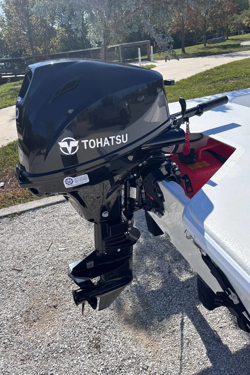 Slide: The Image of 2025 Rabco Buccaneer with Tohatsu outboard motor, parked outdoors. - 5
