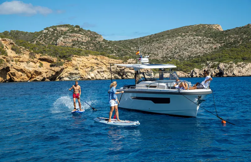 The Image of 2025 Nimbus Tender 11 yacht with paddleboarders in scenic coastal waters. - 0