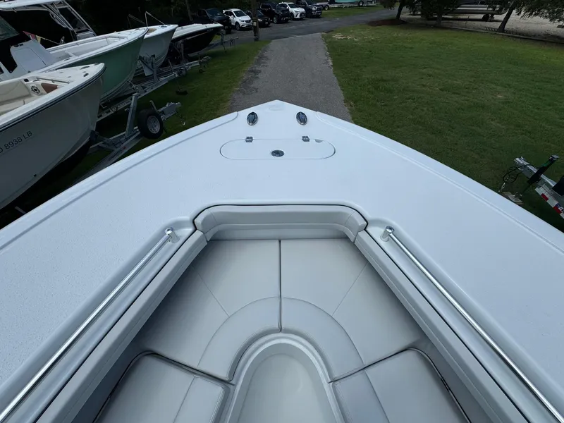 Slide: The Image of 2025 Yellowfin 32 Offshore boat bow view, parked on grass near other boats. - 15