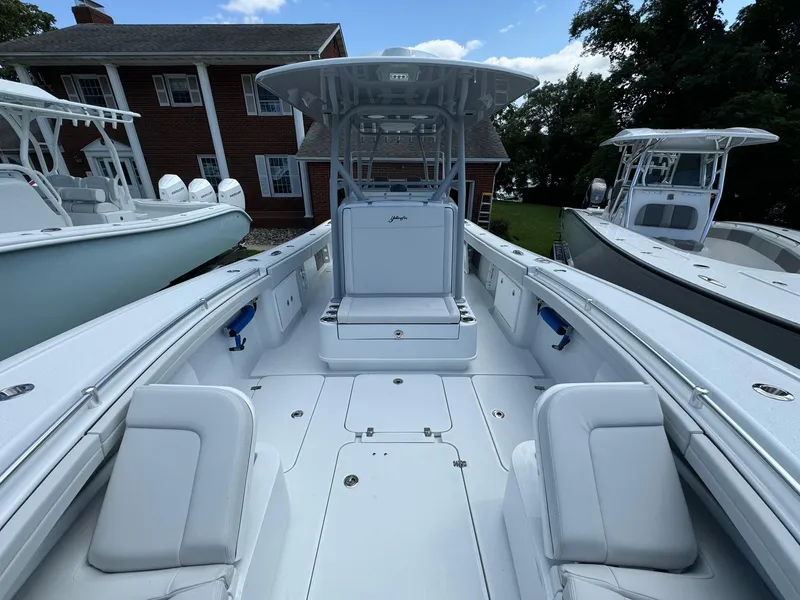 Slide: The Image of 2025 Yellowfin 32 Offshore boat, spacious deck, sleek design, docked near other boats. - 16