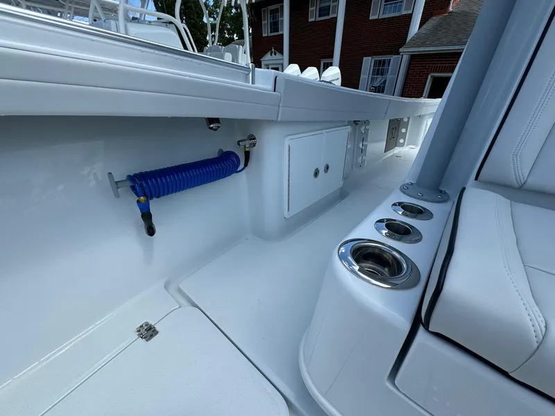 Slide: The Image of 2025 Yellowfin 32 Offshore boat interior with cup holders and coiled hose. - 21