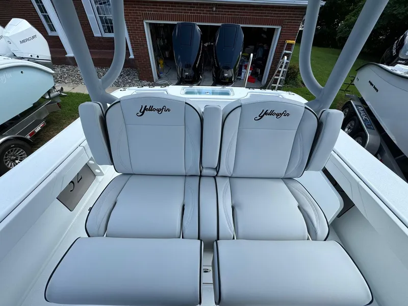 Slide: The Image of 2025 Yellowfin 32 Offshore boat interior with cushioned seating and dual engines. - 26