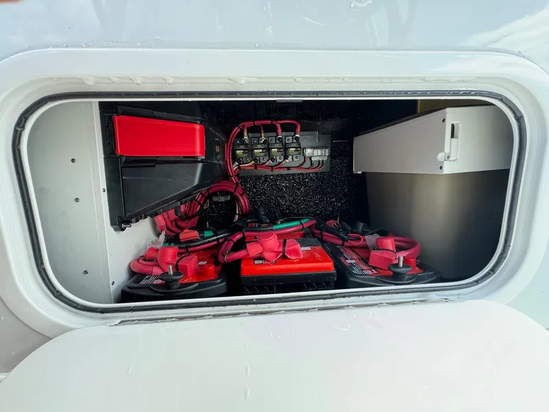 Slide: The Image of Battery compartment of 2025 Yellowfin 32 Offshore boat, featuring red cables and secure storage. - 30