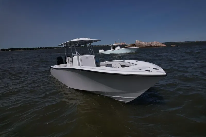Slide: The Image of 2025 Yellowfin 32 Offshore boat on calm water, clear sky background. - 4