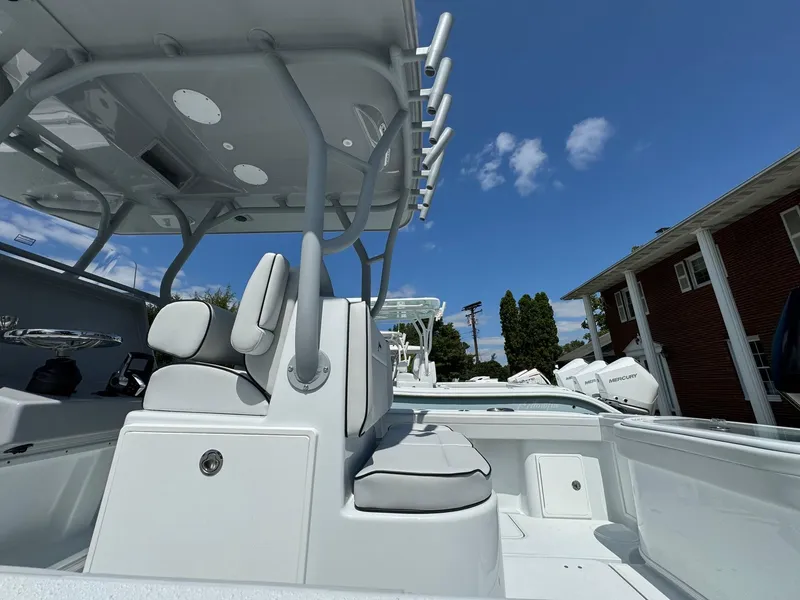 Slide: The Image of 2025 Yellowfin 32 Offshore boat interior with seating and rod holders under a clear sky. - 40