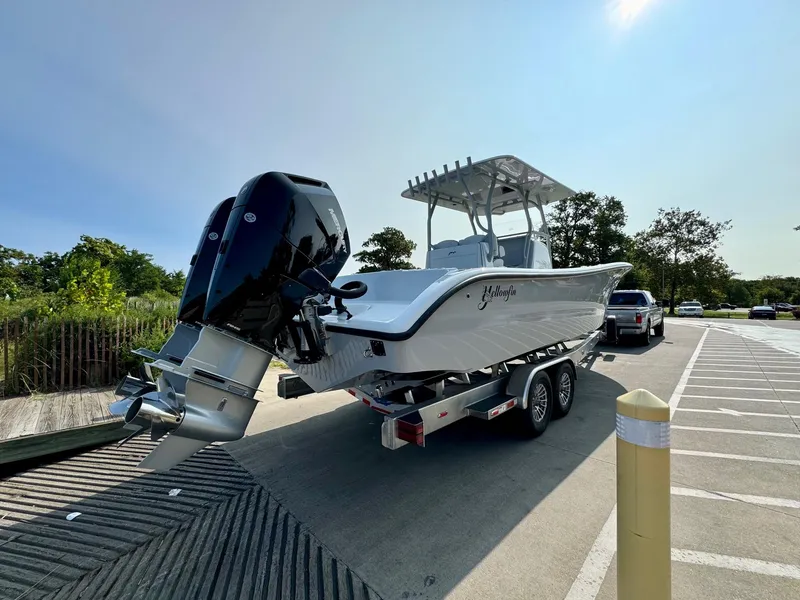 Slide: The Image of 2025 Yellowfin 32 Offshore boat on trailer in parking lot, sunny day. - 6