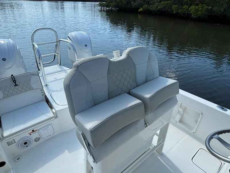 Slide: The Image of 2025 World Cat 235 CC boat interior with cushioned seating and water view. - 10