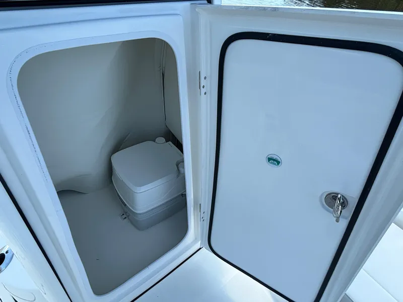Slide: The Image of 2025 World Cat 235 CC boat interior with compact marine toilet. - 14