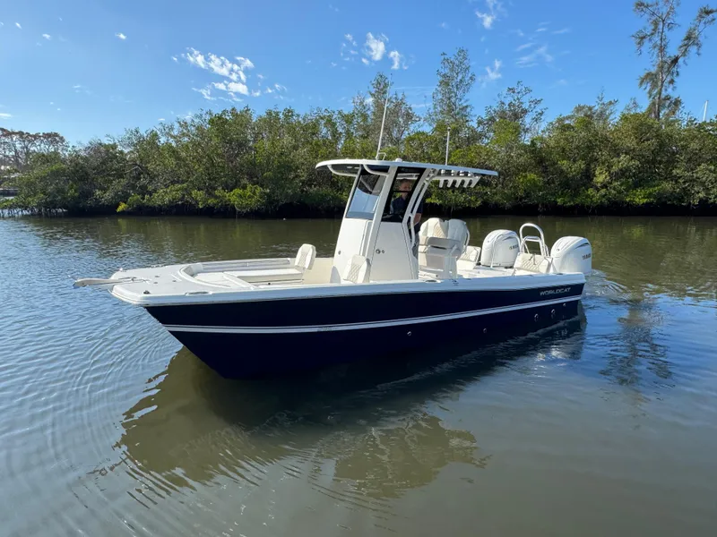 Slide: The Image of 2025 World Cat 235 CC boat on calm water, surrounded by trees. - 4