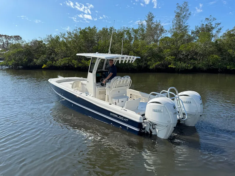 Slide: The Image of 2025 World Cat 235 CC boat with dual Yamaha engines on a calm river. - 6