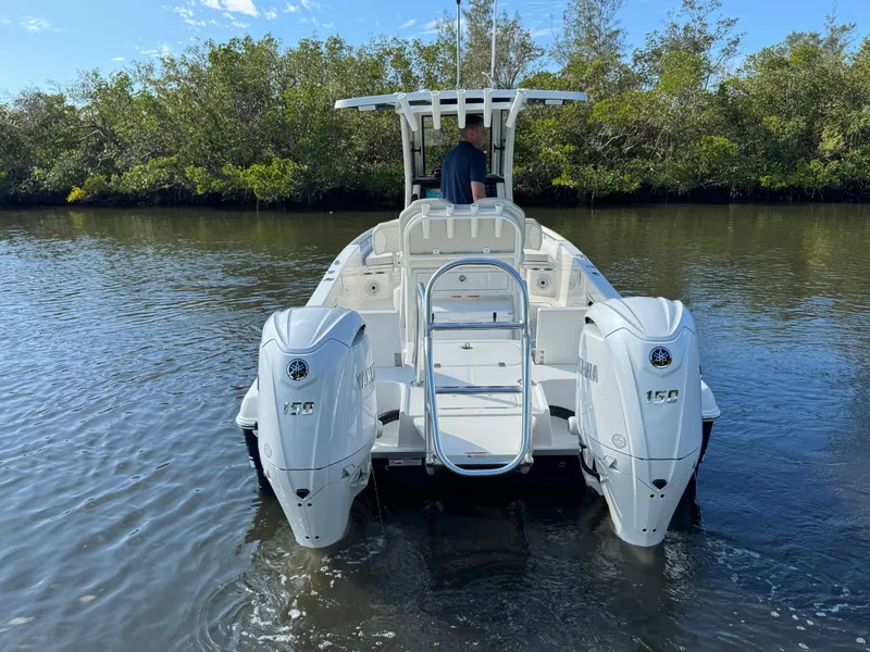 Slide: The Image of 2025 World Cat 235 CC boat with dual engines on calm water. - 7