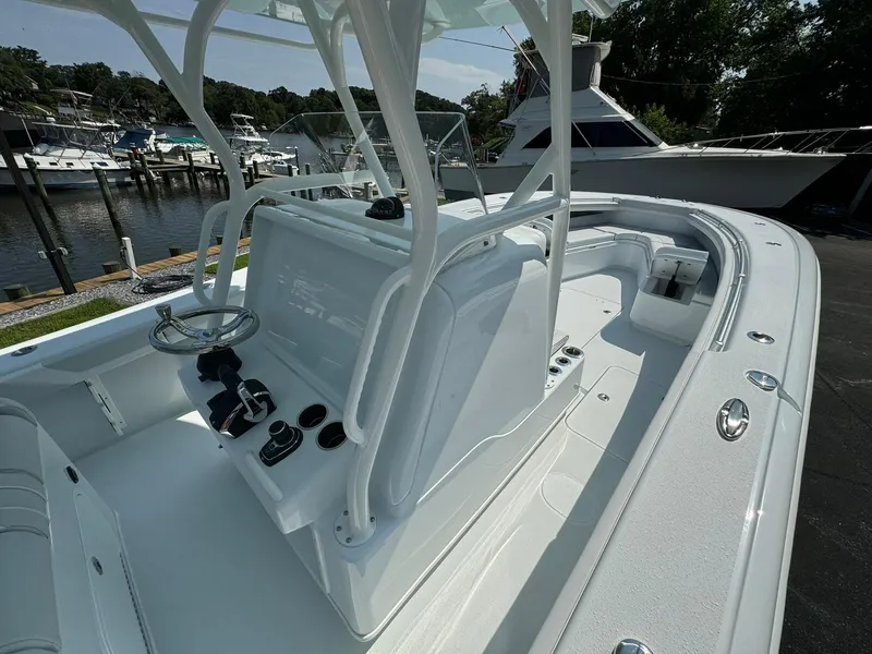 Slide: The Image of 2025 Yellowfin 34 Offshore boat interior with steering console, docked near other boats. - 16