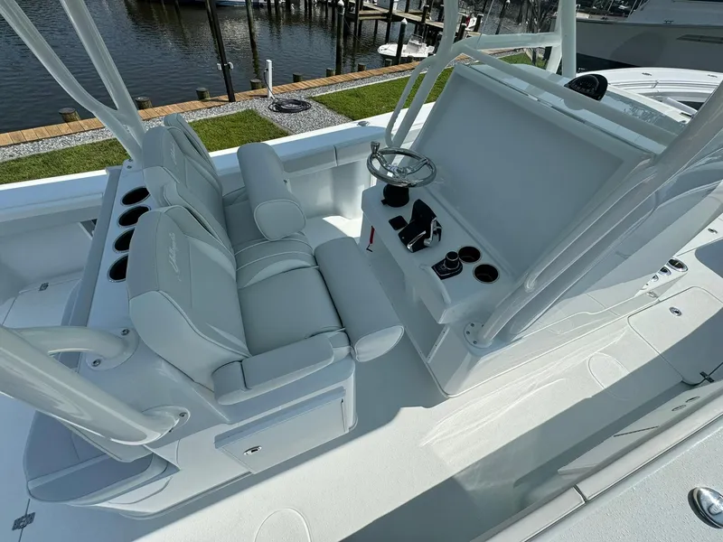 Slide: The Image of 2025 Yellowfin 34 Offshore boat interior with helm and seating, dockside view. - 17