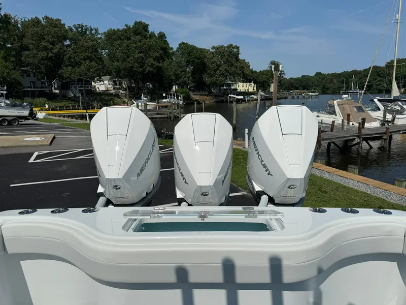 Slide: The Image of 2025 Yellowfin 34 Offshore boat with triple Mercury outboard engines at a marina. - 24