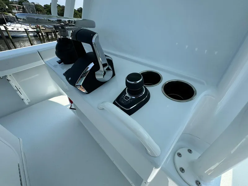 Slide: The Image of 2025 Yellowfin 34 Offshore boat controls and cup holders on deck. - 38