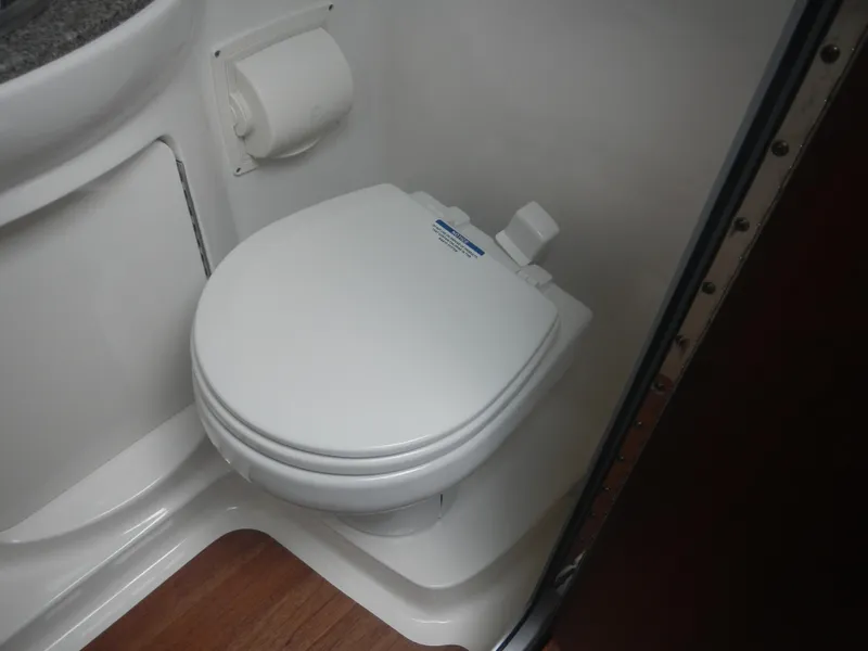 Slide: The Image of 2017 Chaparral 270 Signature boat bathroom with compact toilet and wooden flooring. - 33