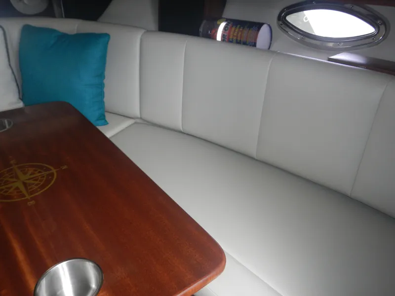 Slide: The Image of 2017 Chaparral 270 Signature interior with white seating and wooden table. - 39