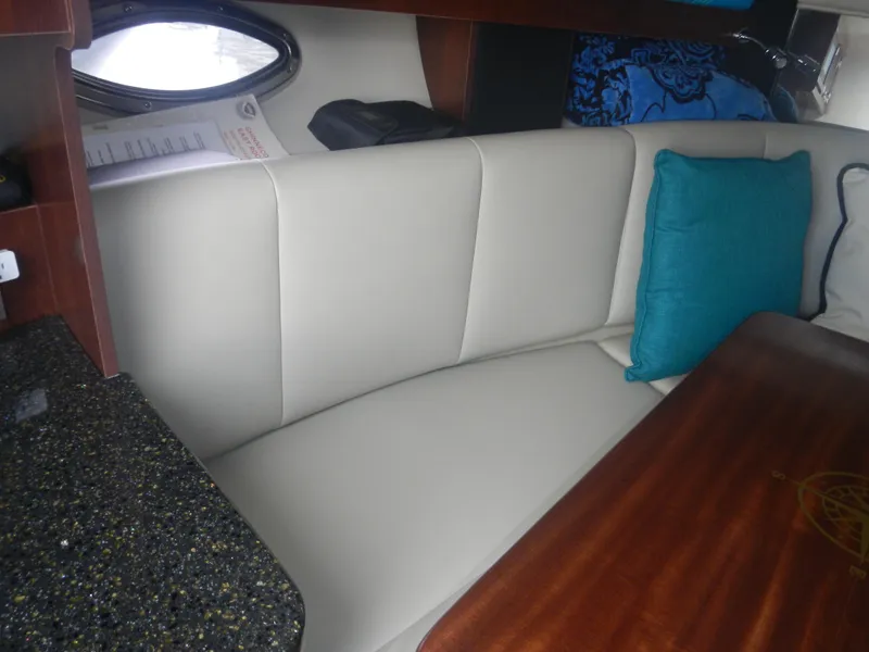 Slide: The Image of Interior of 2017 Chaparral 270 Signature with cushioned seating and wooden table. - 40