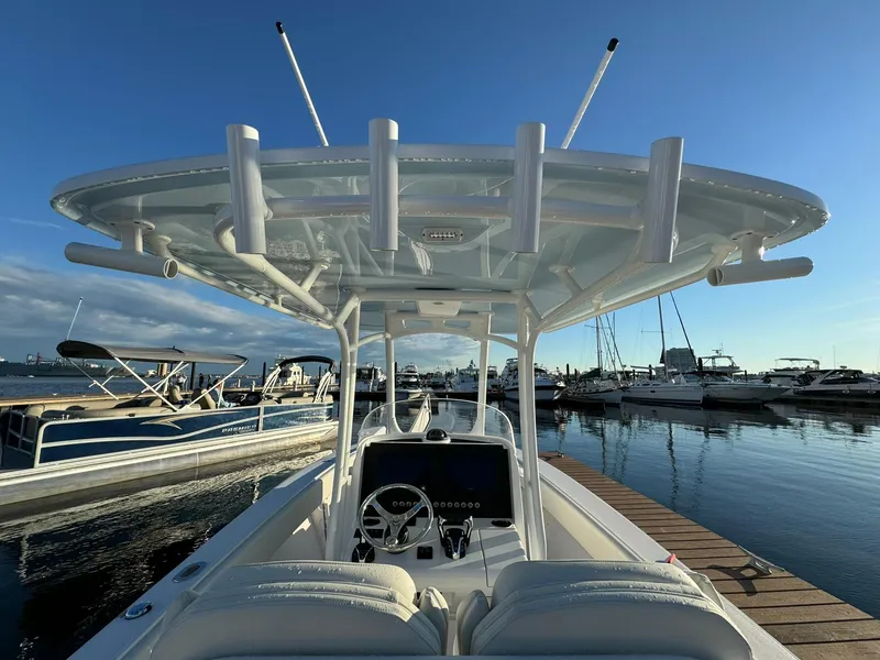Slide: The Image of 2024 Jupiter 26 FS boat docked at marina under clear blue sky. - 18