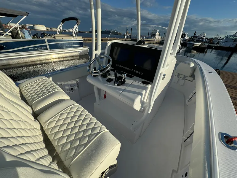 Slide: The Image of 2024 Jupiter 26 FS boat interior with white quilted seats and modern dashboard. - 9