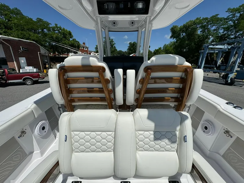 Slide: The Image of 2024 Jupiter 340LS boat interior with white leather seats and wooden accents. - 11