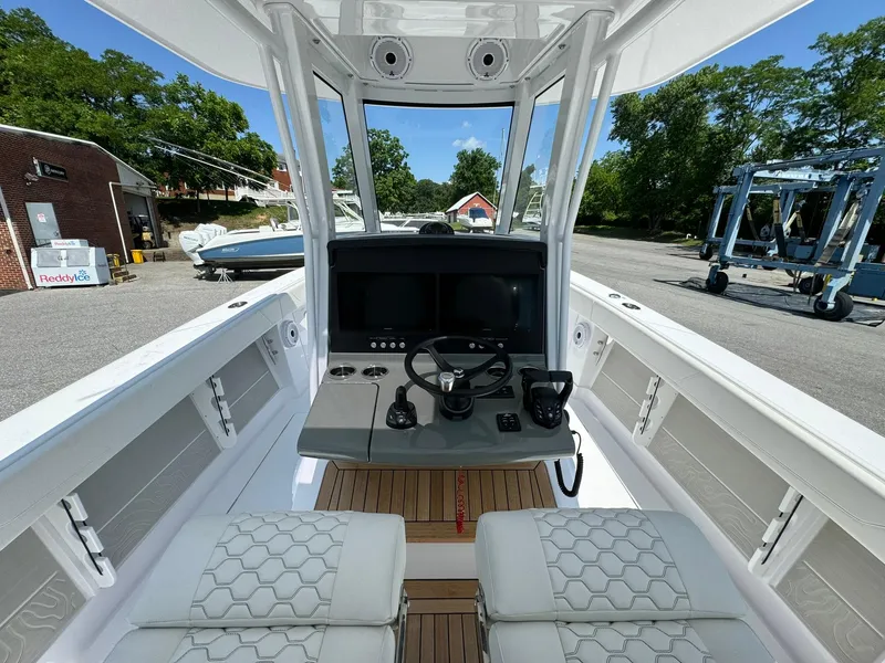 Slide: The Image of 2024 Jupiter 340LS boat cockpit with modern controls and seating, docked outdoors. - 13