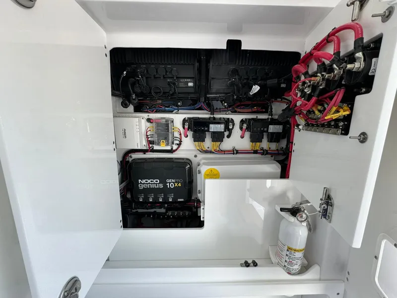 Slide: The Image of Electrical panel inside 2024 Jupiter 340LS boat, featuring NOCO Genius charger and wiring. - 25