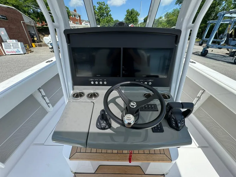 Slide: The Image of 2024 Jupiter 340LS boat dashboard with dual screens and steering wheel. - 26