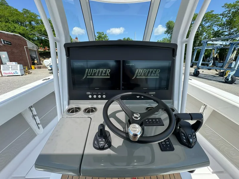 Slide: The Image of 2024 Jupiter 340LS boat dashboard with dual screens and steering wheel. - 28