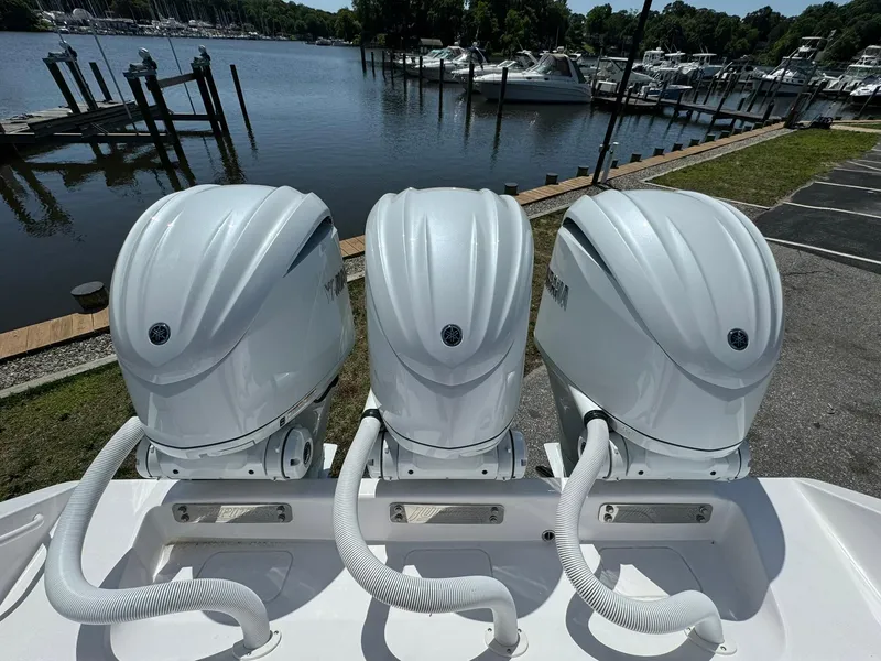 Slide: The Image of Triple outboard motors on a 2024 Jupiter 340LS boat by a marina. - 9