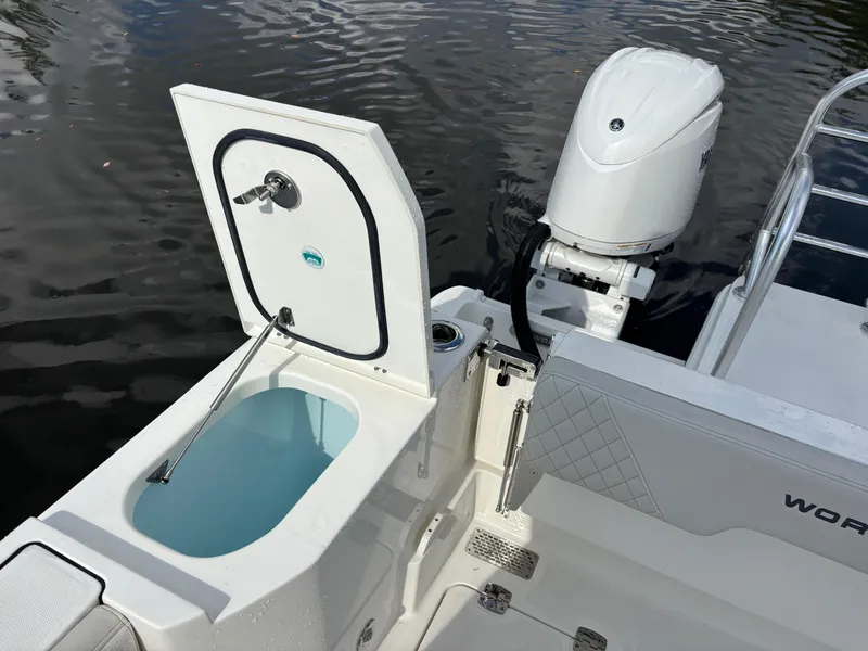Slide: The Image of 2025 World Cat 260 CC-X boat with open storage compartment and outboard motor. - 12