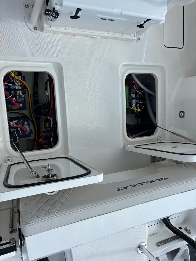 Slide: The Image of 2025 World Cat 260 CC-X boat interior with open storage compartments and visible wiring. - 19