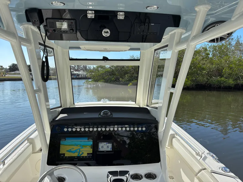 Slide: The Image of 2025 World Cat 260 CC-X boat cockpit with navigation system on a calm waterway. - 21