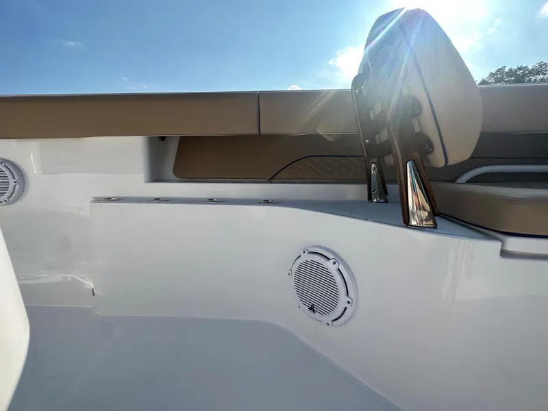 Slide: The Image of 2024 Jupiter 43 boat interior with cushioned seating and speaker, under bright sunlight. - 21