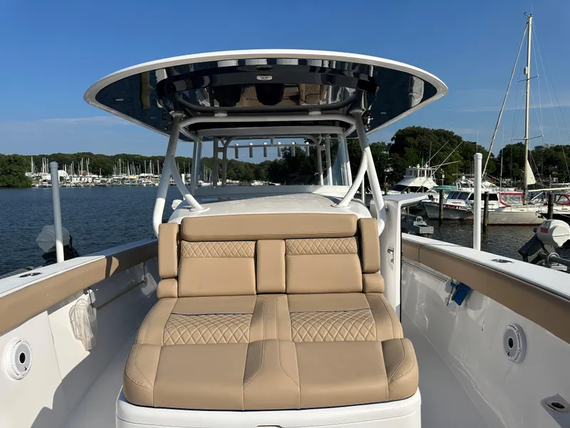 Slide: The Image of 2024 Jupiter 43 boat with tan seating, docked at a marina under clear skies. - 22