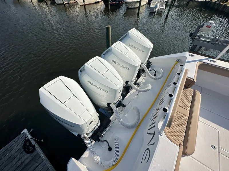 Slide: The Image of 2024 Jupiter 43 boat with four Mercury outboard engines docked at marina. - 7