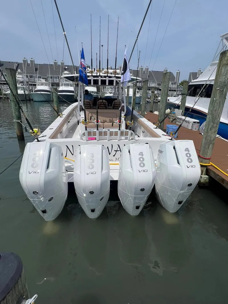 Slide: The Image of 2024 Jupiter 43 boat with four powerful outboard engines docked at a marina. - 8