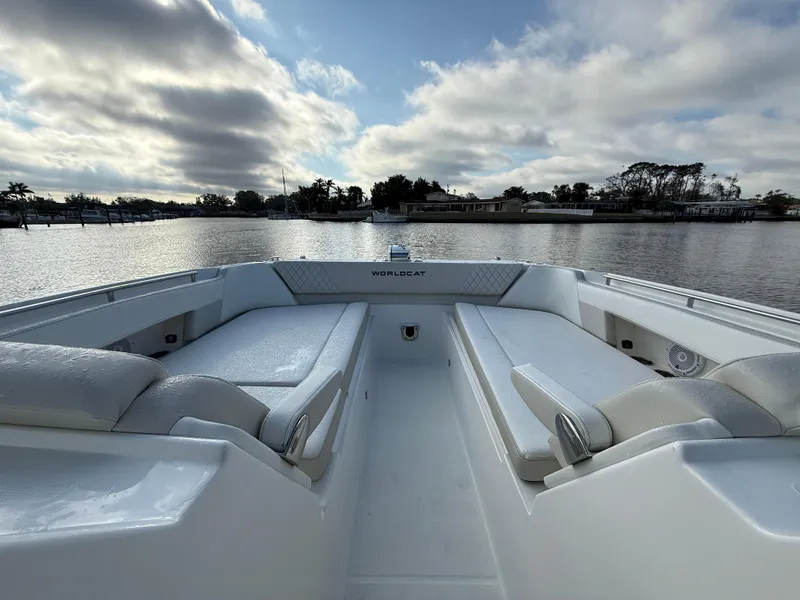 Slide: The Image of 2025 World Cat 325 DC boat interior with spacious seating on a calm lake. - 10