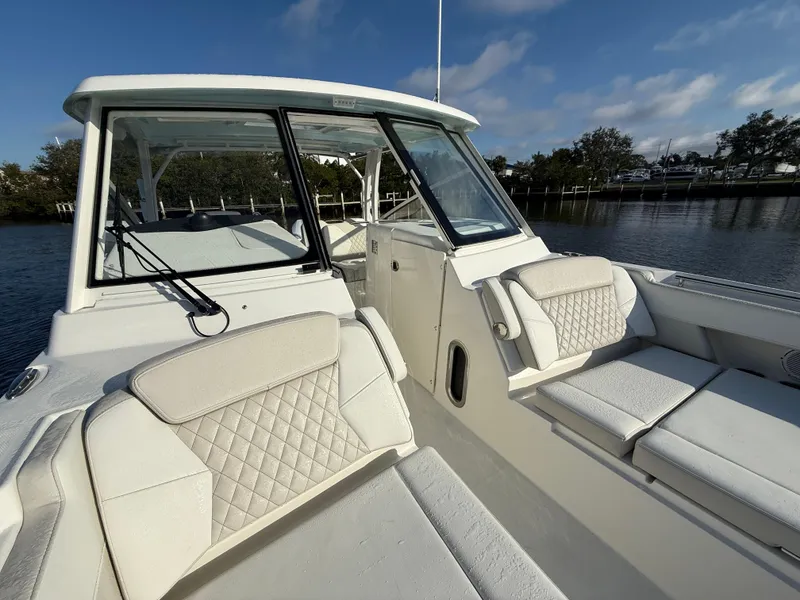 Slide: The Image of 2025 World Cat 325 DC boat with spacious seating and modern design on a calm waterway. - 14