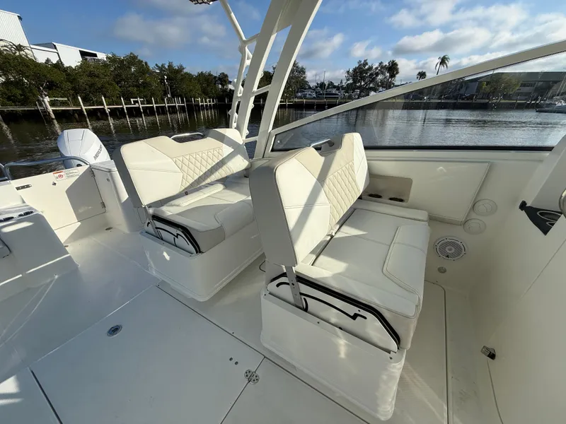 Slide: The Image of 2025 World Cat 325 DC boat interior with white seating and waterfront view. - 15