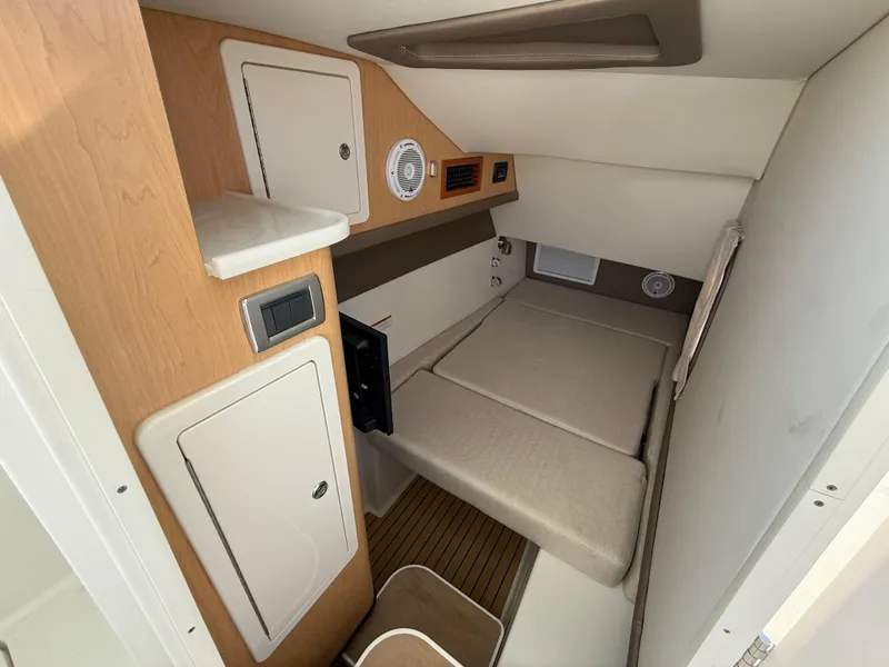 Slide: The Image of 2025 World Cat 325 DC cabin interior with compact sleeping area and storage. - 16