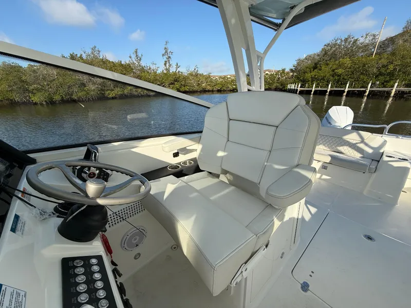 Slide: The Image of 2025 World Cat 325 DC boat interior with steering wheel and comfortable seating. - 21