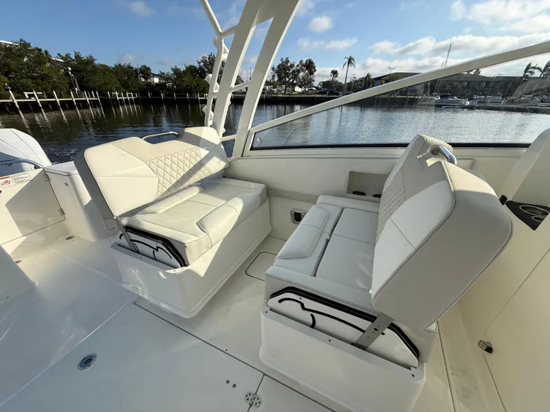 Slide: The Image of 2025 World Cat 325 DC boat interior with white seating and waterfront view. - 22
