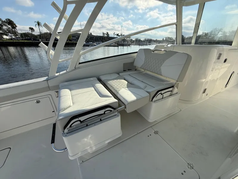 Slide: The Image of Luxurious seating on 2025 World Cat 325 DC boat, docked by a scenic waterfront. - 23