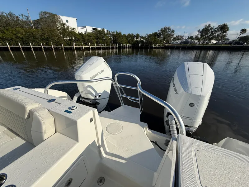 Slide: The Image of 2025 World Cat 325 DC boat with dual Mercury engines on a calm river. - 25