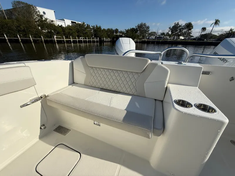 Slide: The Image of 2025 World Cat 325 DC boat interior with cushioned seating and cup holders. - 26