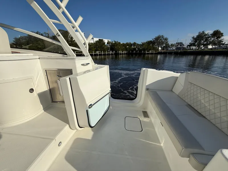 Slide: The Image of 2025 World Cat 325 DC boat interior with seating and storage, on calm water. - 28