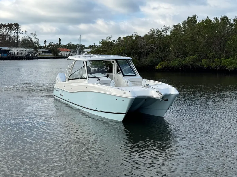 Slide: The Image of 2025 World Cat 325 DC boat cruising on a calm river. - 3