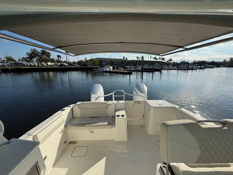 Slide: The Image of 2025 World Cat 325 DC boat interior with seating, overlooking a serene marina. - 31